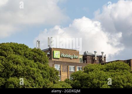 08-12-2021 Portsmouth, Hampshire, UK The Sign of Holiday Inn Hotel à travers les arbres Banque D'Images