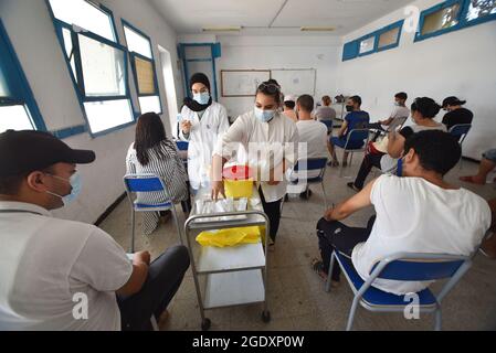 Tunis, Tunisie. 15 août 2021. Les travailleurs de la santé se préparent à administrer des doses du vaccin Moderna COVID-19 à des personnes dans un centre d'inoculation situé dans un bâtiment du lycée de la capitale Tunis.le directeur général de la santé tunisien Faycel Ben Salah a déclaré que près d'un million de personnes seront appelées à la 2e journée de vaccination intensive contre le coronavirus, cibler les 18-39 groupes d'âge. Crédit : SOPA Images Limited/Alamy Live News Banque D'Images