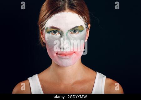 Jeune femme appliquant le maquillage, peint le visage avec pinceau et maquillage. Comment ne pas faire le clown de cirque de concept de maquillage Banque D'Images