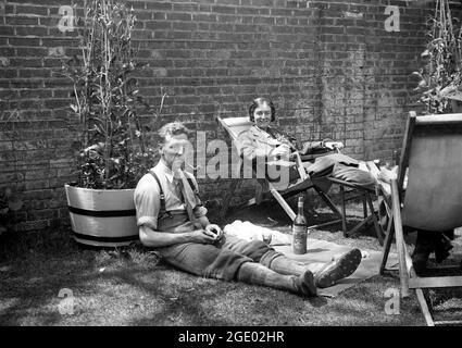 Couple détente en famille dans le jardin avec un verre de Martini en Grande-Bretagne 1923 Banque D'Images