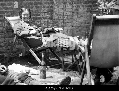 Femme dame se détendant dans le jardin avec un verre de Martini en Grande-Bretagne 1923 Banque D'Images