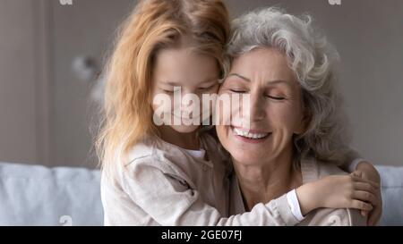 Petite petite petite-fille embrasse la vieille grand-mère montrant l'amour Banque D'Images