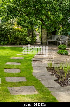 Un chemin à travers une pelouse menant à une porte ouverte dans le Yorkshire. Banque D'Images