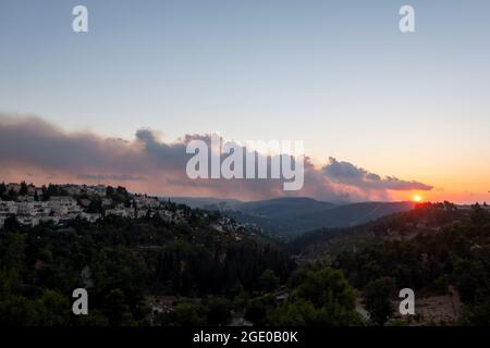 La fumée s'élève après l'incendie d'une forêt qui a éclaté dans la périphérie de la ville le 15 août 2021 à Jérusalem, en Israël. Un énorme feu de forêt s'est propagé près de Jérusalem, brûlant des centaines de dunams de forêt et mettant en danger les communautés voisines. Banque D'Images