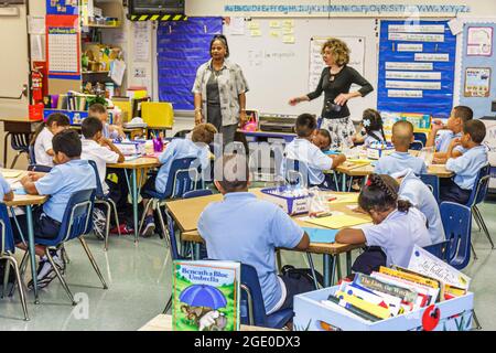 Miami Florida,Comstock Elementary School,Black Woman enseignante enseignant enseignants, élèves garçons filles classe tables de classe interne ville éducation, Banque D'Images