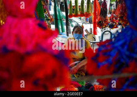 Kolkata, Inde. 14 août 2021. Une femme qui fait et vend 'Rakhi' un fil sacré dans son magasin avant le festival Raksha Bandhan à Kolkata. (Photo de Sudipta Das/Pacific Press) crédit: Pacific Press Media production Corp./Alay Live News Banque D'Images