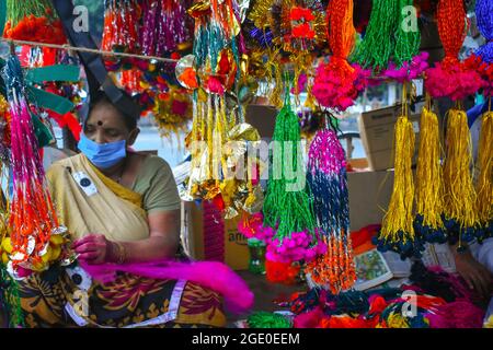 Kolkata, Inde. 14 août 2021. Une femme qui fait et vend 'Rakhi' un fil sacré dans son magasin avant le festival Raksha Bandhan à Kolkata. (Photo de Sudipta Das/Pacific Press) crédit: Pacific Press Media production Corp./Alay Live News Banque D'Images