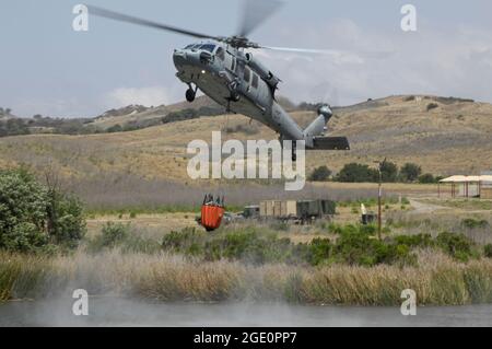 U S Navy MH60S descend pour remplir Bambi Bucket d'un lac sur MCB Camp Pendleton, Californie Banque D'Images