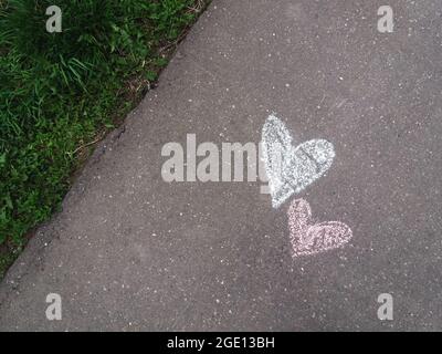 Coeurs dessinés avec de la craie sur le trottoir d'asphalte Banque D'Images