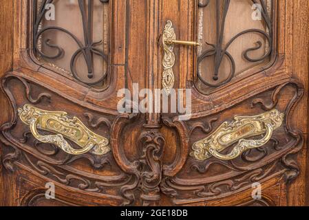 Vue courte d'une ancienne porte avant en bois avec garniture en bronze. Banque D'Images