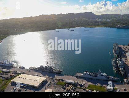 Port de l'APRA, Guam (août 11, 2021) - une vue aérienne de la base navale américaine de Guam montre plusieurs navires amarrés dans le port d'Apra, y compris des navires du groupe de grève des transporteurs du Royaume-Uni 21, août 9. Le déploiement est le premier au Royaume-Uni par un groupe de grève des transporteurs dans l'Indo-Pacifique depuis près de 25 ans et marque une réalisation historique dans le partenariat bilatéral entre les États-Unis et le Royaume-Uni. Le destructeur de missiles guidé de classe Arleigh Burke, USS The Sullivans (DDG-68), est déployé avec le groupe de grève. Tout comme les chasseurs F-35B Lightning II de l'escadron d'attaque de chasseurs maritimes 211, le HMS Queen Elizabe Banque D'Images