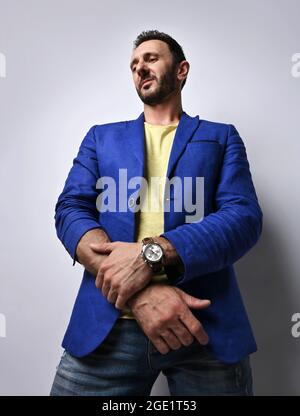 Portrait d'un homme mûr non rasé dans un Jean bleu moderne, une veste et un t-shirt jaune regardant l'appareil photo Banque D'Images