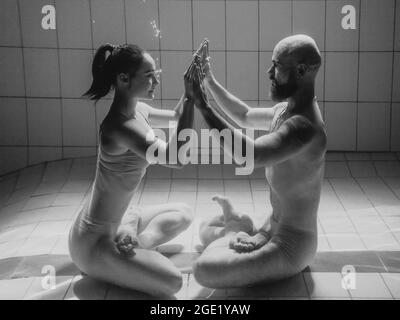 portrait sous l'eau de l'atlethique, la danse sportive et faisant le yoga asanas couple (homme et femme) sous l'eau dans la piscine Banque D'Images