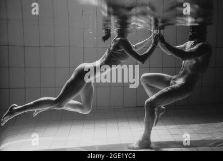 portrait sous l'eau de l'atlethique, la danse sportive et faisant le yoga asanas couple (homme et femme) sous l'eau dans la piscine Banque D'Images