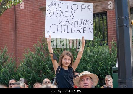 New York, États-Unis. 15 août 2021. Une jeune fille porte un signe qui dit arrêter de laver les enfants au cerveau lors d'un rassemblement républicain contre les mandats de vaccin COVID à l'extérieur de Gracie Mansion à New York.NYC le mandat de vaccin commence le lundi 16 août; Une preuve de vaccination contre le coronavirus (COVID-19) sera requise pour se rendre dans les restaurants intérieurs, les salles de gym et les lieux de divertissement, avec l'application du mandat de commencer le 13 septembre. Crédit : SOPA Images Limited/Alamy Live News Banque D'Images