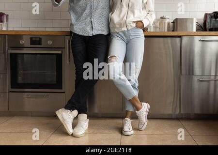 Un couple africain méconnaissable se tenant sur un sol carrelé dans la cuisine Banque D'Images