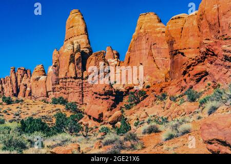 Voitures autoroute peint désert coloré Grass jaune terres Orange grès Rouge four arches Parc national Moab Utah USA Southwest. Banque D'Images