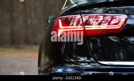 GRODNO, BÉLARUS - DÉCEMBRE 2019 : Audi A6 4G, C7 2016 feu arrière moderne à LED arrière gauche ou feu arrière de voiture métallique noire gros plan sélectif Banque D'Images