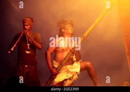 Festival Kardigay Dipam sur le mont Arunachala. Il y a 2 hommes sur la photo. L'un allume un feu, l'autre joue un tuyau Banque D'Images