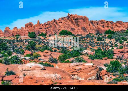 Voitures autoroute peint désert coloré Grass jaune terres Orange grès Rouge four arches Parc national Moab Utah USA Southwest. Banque D'Images