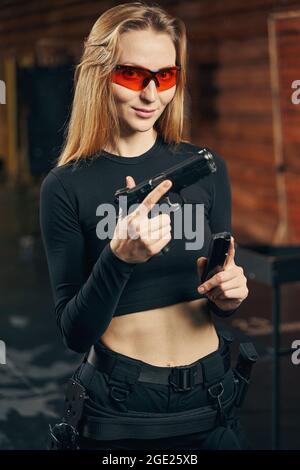 Femme en lunettes de protection tenant un pistolet Banque D'Images