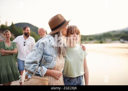 Bonne famille multigénération pendant les vacances d'été, à pied au bord du lac. Banque D'Images