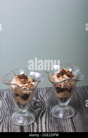 Dessert avec crème et chapelure de biscuits. Se tient sur des planches de pin. Gros plan. Banque D'Images