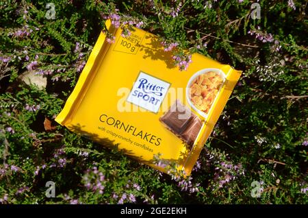 Sonderborg, Danemark - Augut 15, 2021: Ritter Sport jaune cornlflakes chocolat brique arrangé en fleur de bruyère. Banque D'Images