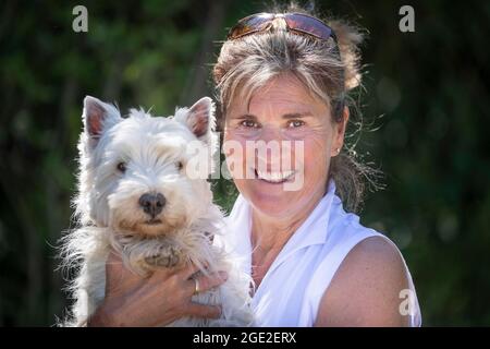 Femme tenant un West Highland White Terrier adulte Banque D'Images