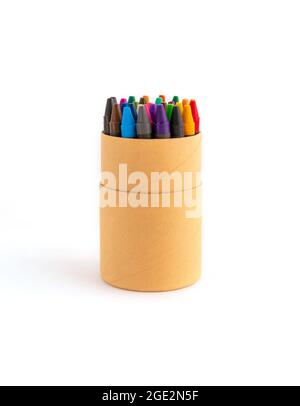 Crayons cireux colorés dans une boîte en carton écologique isolée sur fond blanc. Bâtonnets pastel colorés non toxiques de cire pigmentée dans un gobelet en papier pour l'écriture artistique Banque D'Images