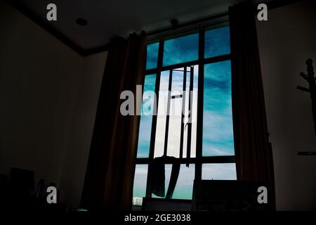 Le vent qui traverse des rideaux colorés et des grilles de fenêtres en fer du ciel bleu à Ho Chi Minh ville, Vietnam. Banque D'Images