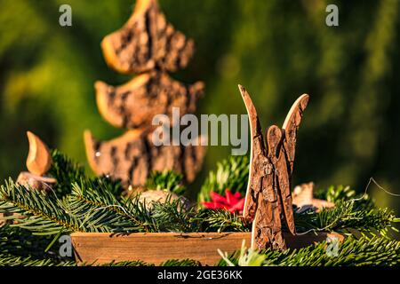 Un arrangement de fleurs avec des branches de sapin et un ange en bois décoré pour Noël Banque D'Images