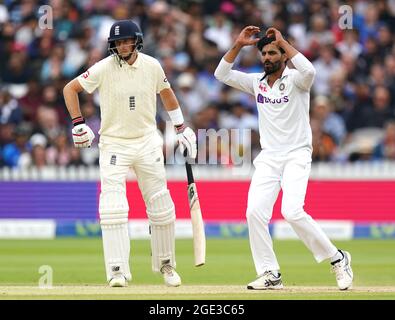 En Inde, Ravindra Jadeja (à droite) réagit alors que Joe Root, de l'Angleterre, regarde pendant le cinquième jour du deuxième match de test de Cinch à Lord's, Londres. Date de la photo: Lundi 16 août 2021. Banque D'Images