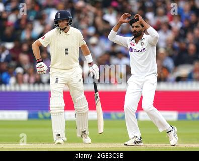 En Inde, Ravindra Jadeja (à droite) réagit alors que Joe Root, de l'Angleterre, regarde pendant le cinquième jour du deuxième match de test de Cinch à Lord's, Londres. Date de la photo: Lundi 16 août 2021. Banque D'Images