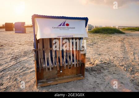 Chaise de plage typique, appelée Strandkorb, sur la plage. Station balnéaire de la mer du Nord Carolinensiel-Harlesiel en Frise orientale, Basse-Saxe, Allemagne. Banque D'Images