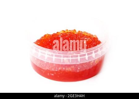 Caviar rouge dans un récipient en plastique sur fond blanc. Stockage de caviar. Fruits de mer. La nourriture est chère Banque D'Images