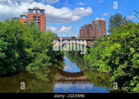 Royaume-Uni, Yorkshire de l'Ouest, Leeds, Pont sur la rivière aire avec des blocs modernes d'appartements en hauteur en arrière-plan. Vue depuis le pont de Monk. Banque D'Images