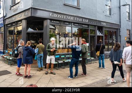 Les clients attendent à l'extérieur de la célèbre boutique de poissons et de copeaux de Grosvenor dans la voie Norwich inférieure de Goat pour la commande Banque D'Images