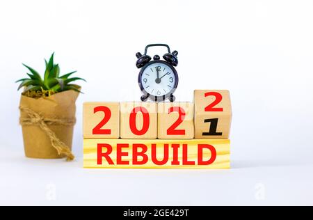 Symbole de la planification de la reconstruction de l'année 2022. Radio-réveil. A tourné un cube en bois, a changé les mots 'Rebuild 2021' en 'Rebuild 2022'. Magnifique fond blanc Banque D'Images