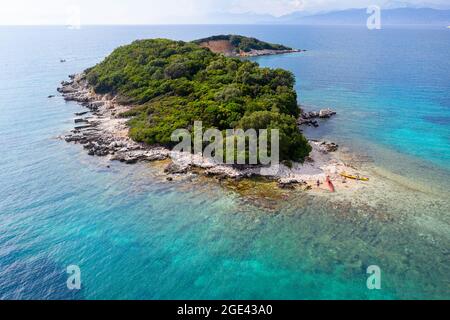 Vue aérienne de la mère et du fils debout sur la plage par leurs kayaks sur l'île de Ksamil, pris par drone, Riviera albanaise Banque D'Images