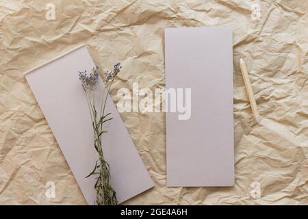 Composition de pose à plat avec un bloc-notes en papier kraft lacrymal, un crayon et de la lavande séchée sur un fond en papier kraft. Vue de dessus. Banque D'Images