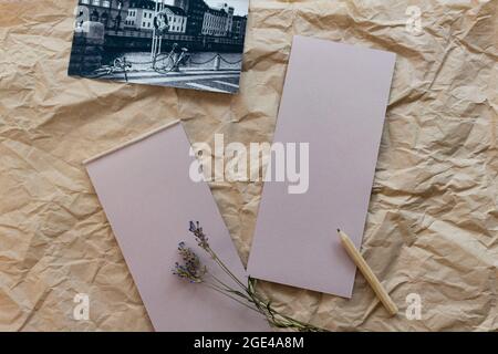 Composition de pose à plat avec un bloc-notes en papier kraft déchirable, un crayon, une carte postale noir-blanc et de la lavande séchée sur un fond en papier kraft. Vue de dessus. Banque D'Images