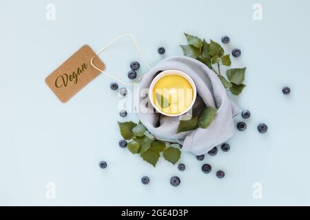 Sans lait, glace à la mangue ou yaourt glacé. Composition alimentaire horizontale avec légumes, crème glacée aux fruits, feuilles et bleuets sur fond bleu Banque D'Images