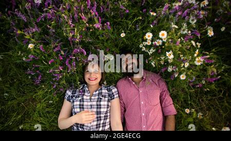 Couple romantique amour moment dans le champ parmi les fleurs sauvages Banque D'Images