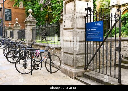 Oxford, Angleterre - juin 2021 : rangée de bicyclettes fixée à des porte-vélos devant l'entrée de l'université de la Faculté d'histoire dans le centre-ville d'Oxford Banque D'Images