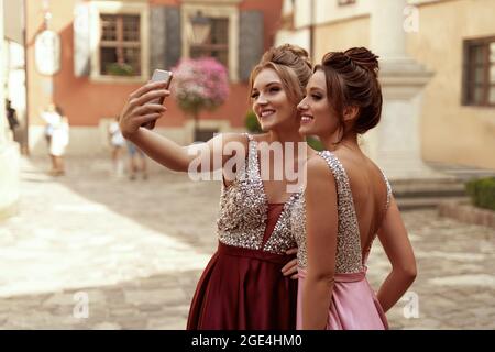 Les jeunes filles européennes prennent le selfie sur leur téléphone mobile en ville Banque D'Images