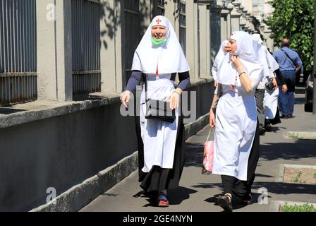 Les religieuses dans les robes d'église et les masques médicaux marchent le long des rues de Kiev. Les religieuses, paroissiens de l'Église orthodoxe marchent à Kiev Banque D'Images