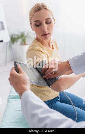 médecin mettant le brassard de tonomètre sur le patient à l'hôpital Banque D'Images