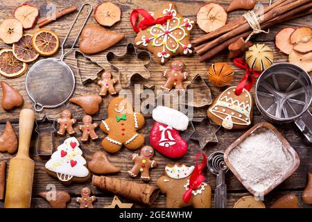 Repas de Noël. Petits gâteaux faits maison au pain d'épice avec ingrédients pour la cuisine de noël et ustensiles de cuisine sur une table en bois, vue du dessus Banque D'Images