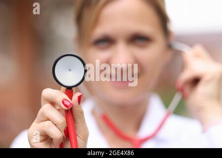 Femme souriante médecin tenant le stéthoscope médical de près Banque D'Images